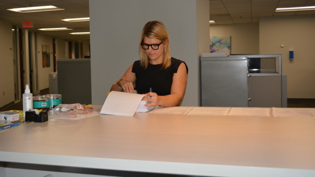 Hannah F. Little reviewing documents at standing desk.