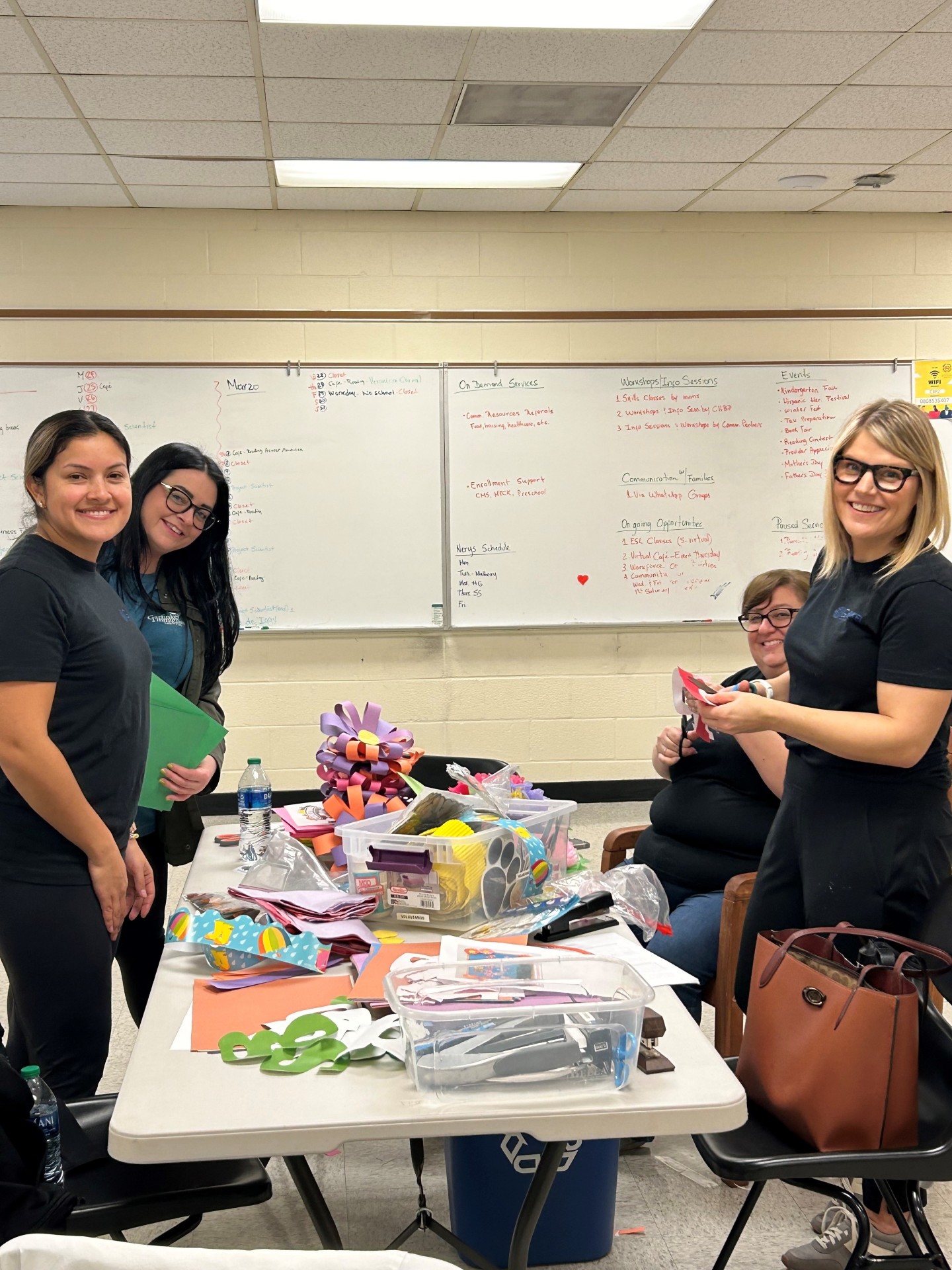 Members of the Garfinkel Immigration Law Firm staff working on items for a bulletin board. 