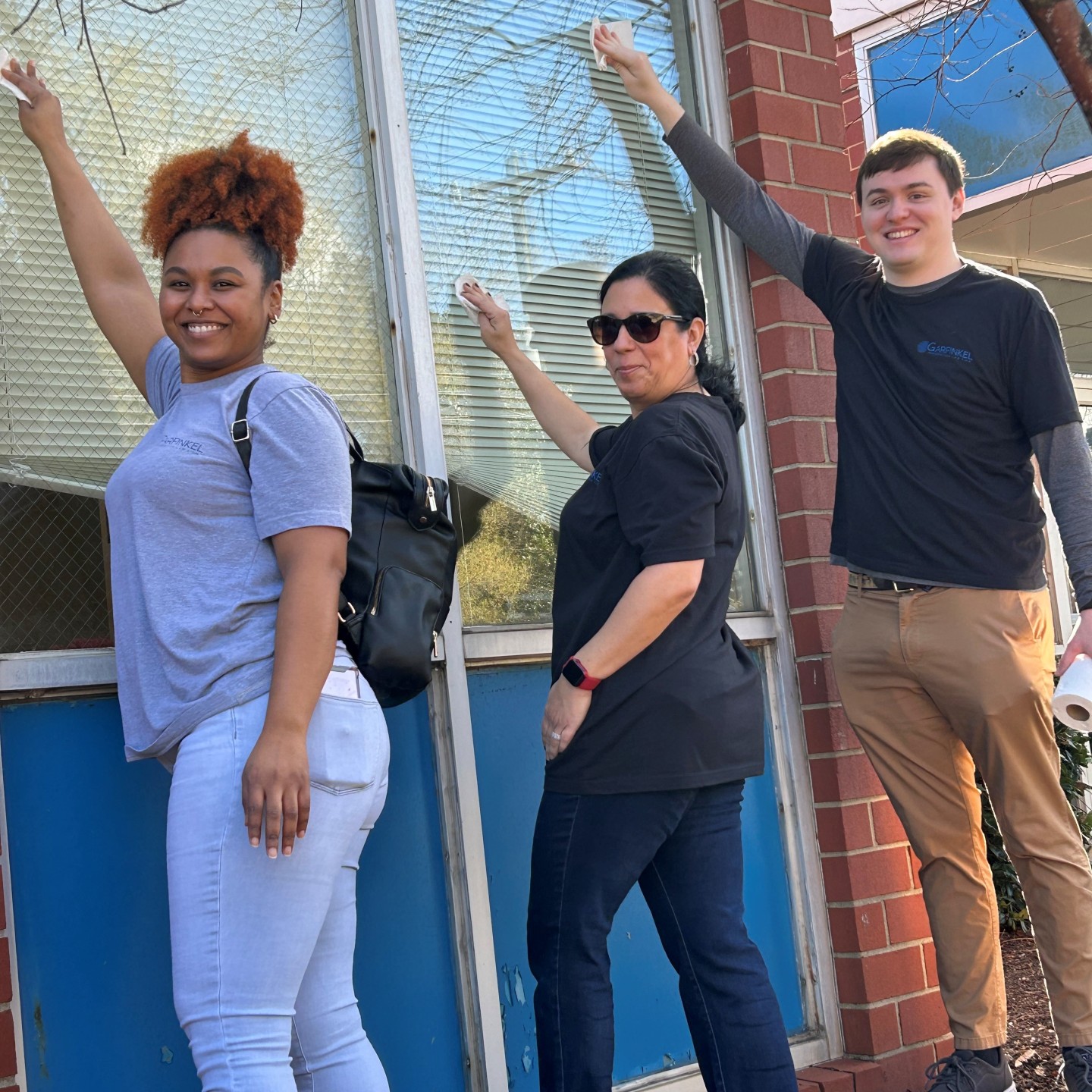 Members of Garfinkel Immigration Law Firm washing windows at the Charlotte Bilingual Preschool. 