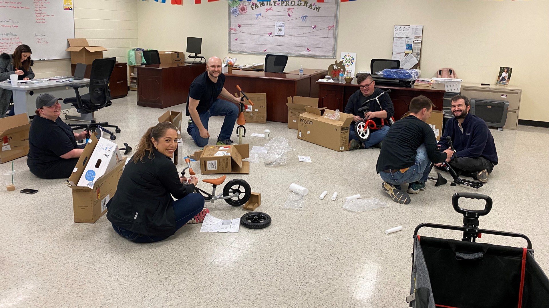 Members of Garfinkel Immigration Law Firm building bicycles at the Charlotte Bilingual Preschool. 