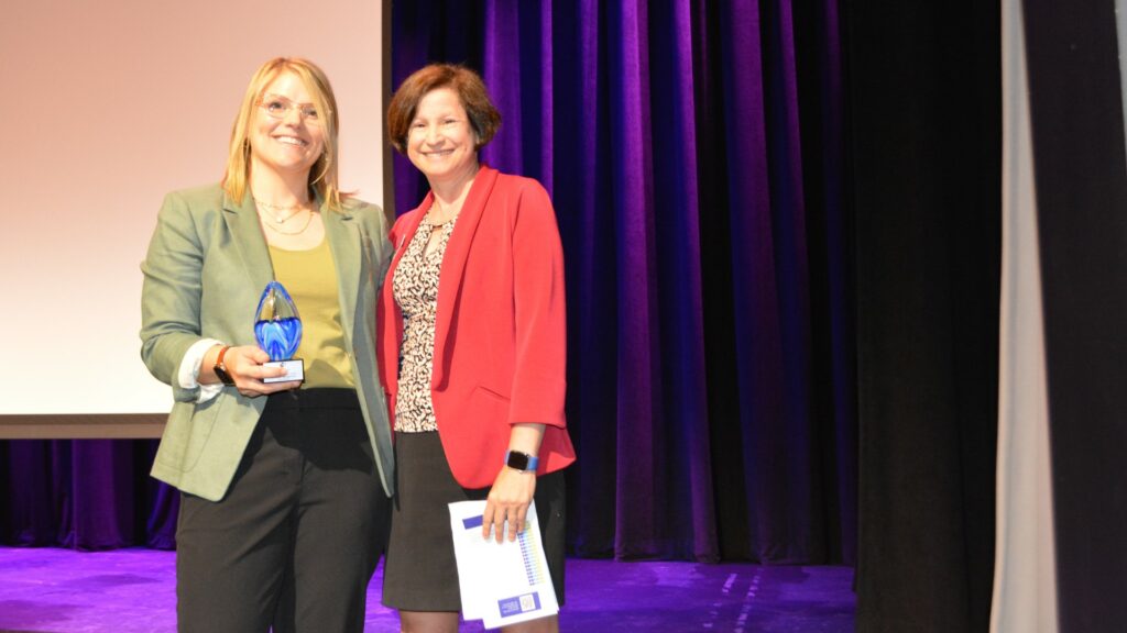 Garfinkel Immigration Managing Partner Hannah F. Little accepts the "Pro Bono Firm of the Year" award from IMMPAV Managing Attorney Rona Karacaova.