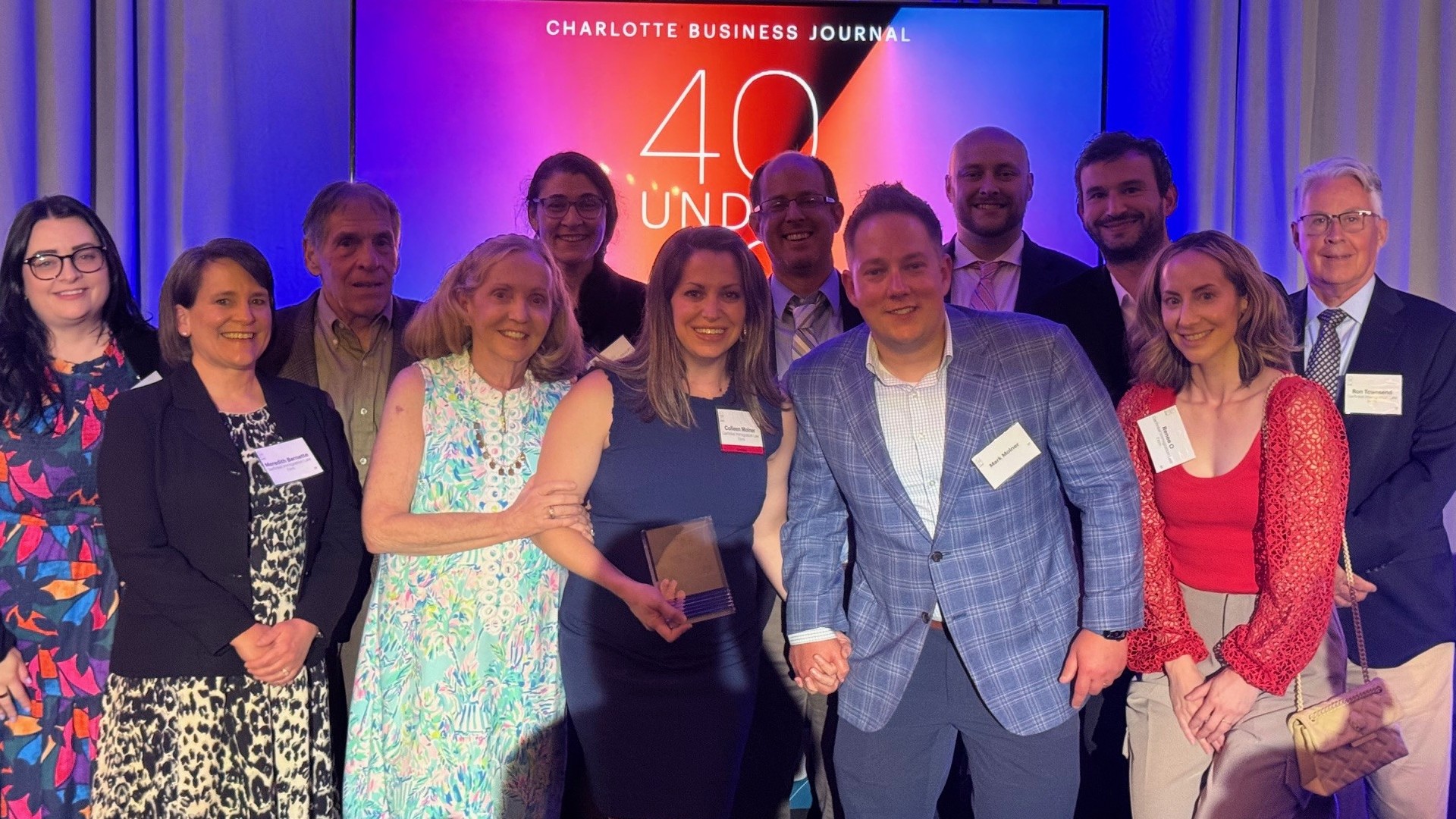 Colleen's family and coworkers with the 40 Under 40 Award. 