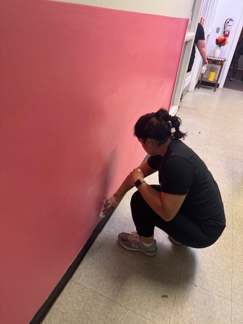 A member of Garfinkel Immigration Law Firm paints a wall.